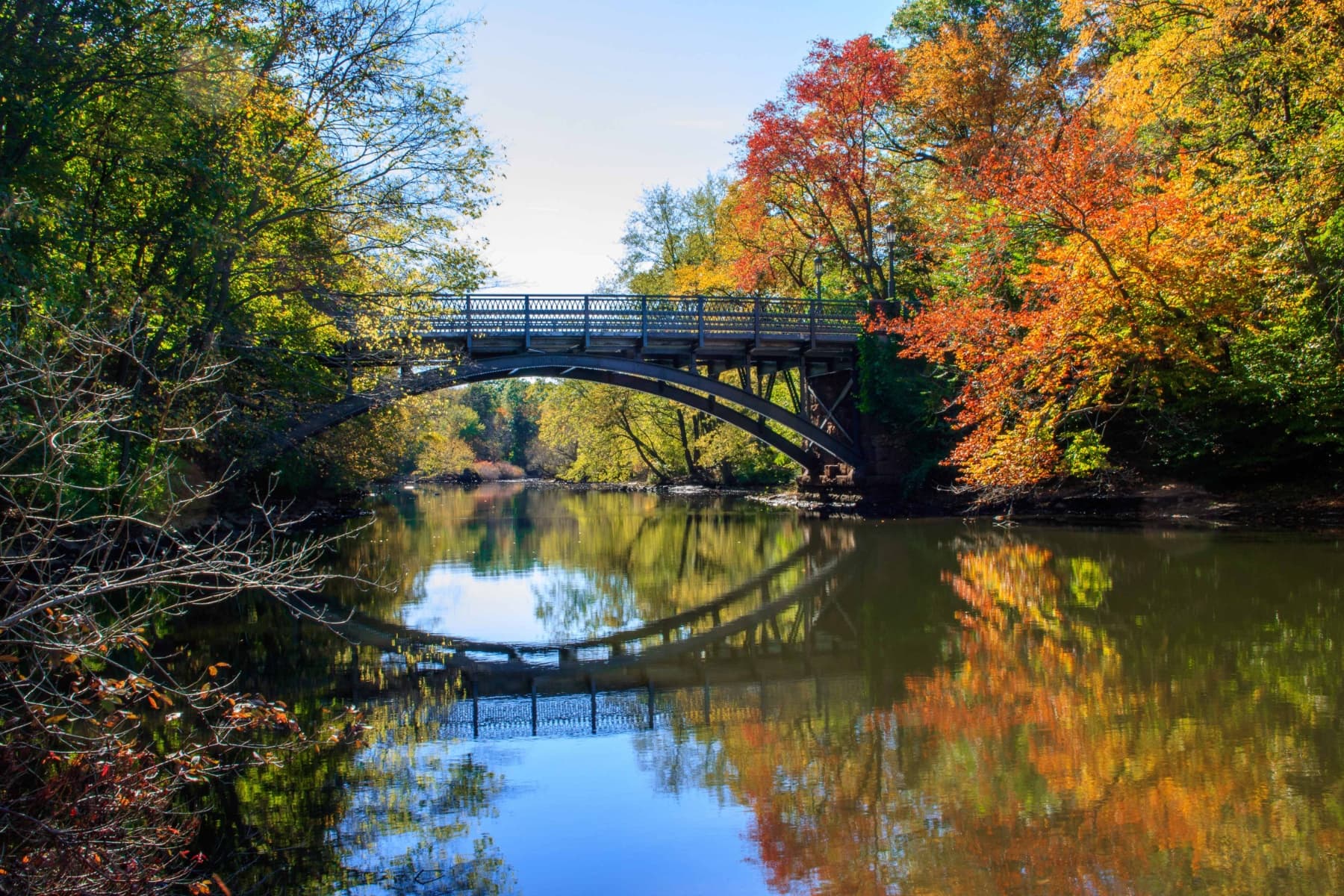 Arched footbridge over a calm river